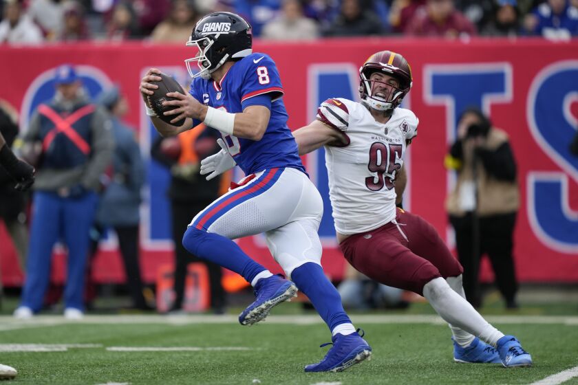 Washington Commanders' Casey Toohill, right, tries to stop New York Giants quarterback Daniel Jones during the second half of an NFL football game, Sunday, Dec. 4, 2022, in East Rutherford, N.J. (AP Photo/John Minchillo)