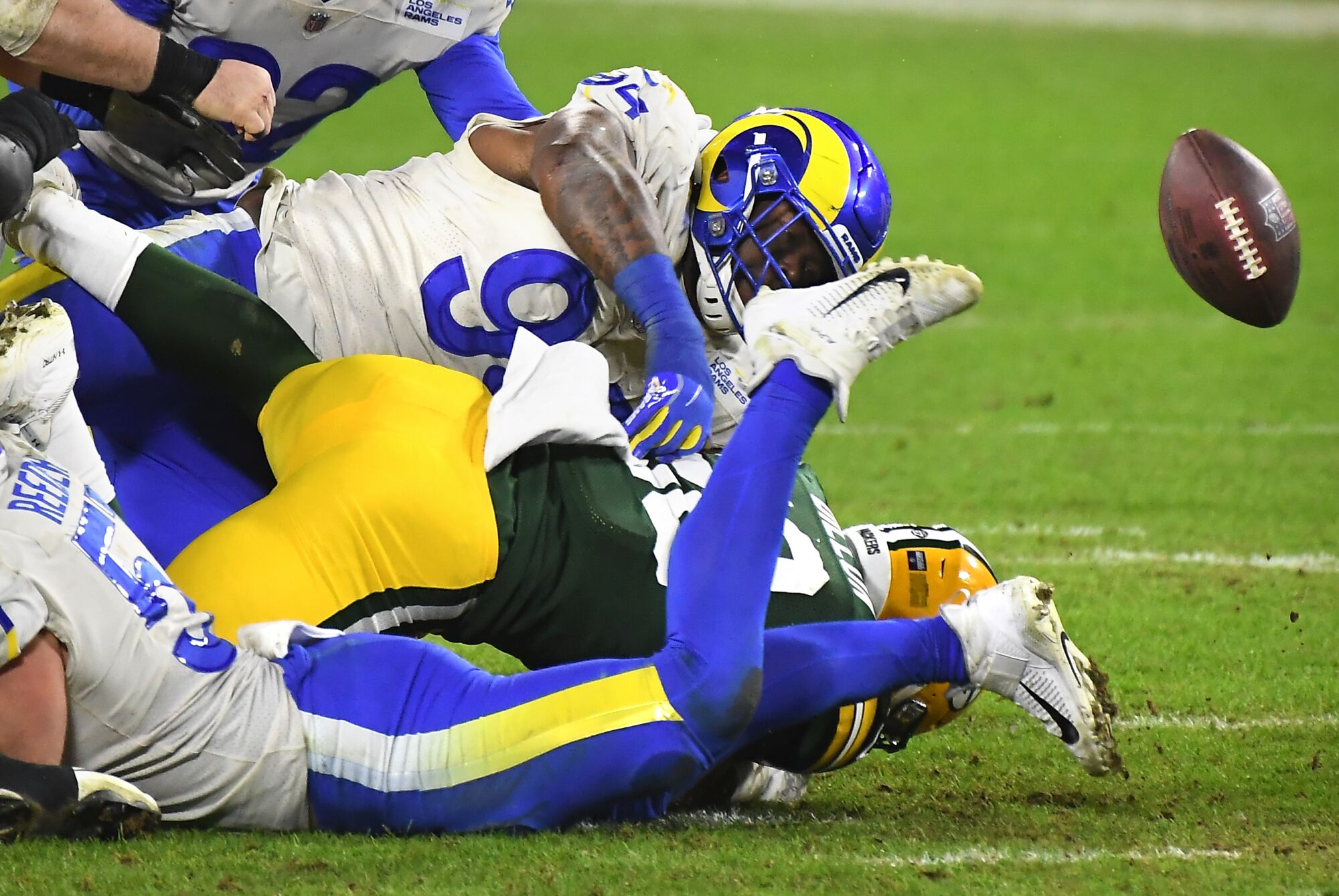 Green Bay Packers running back AJ Dillon fumbles the ball as Rams defenders look on in the fourth quarter.
