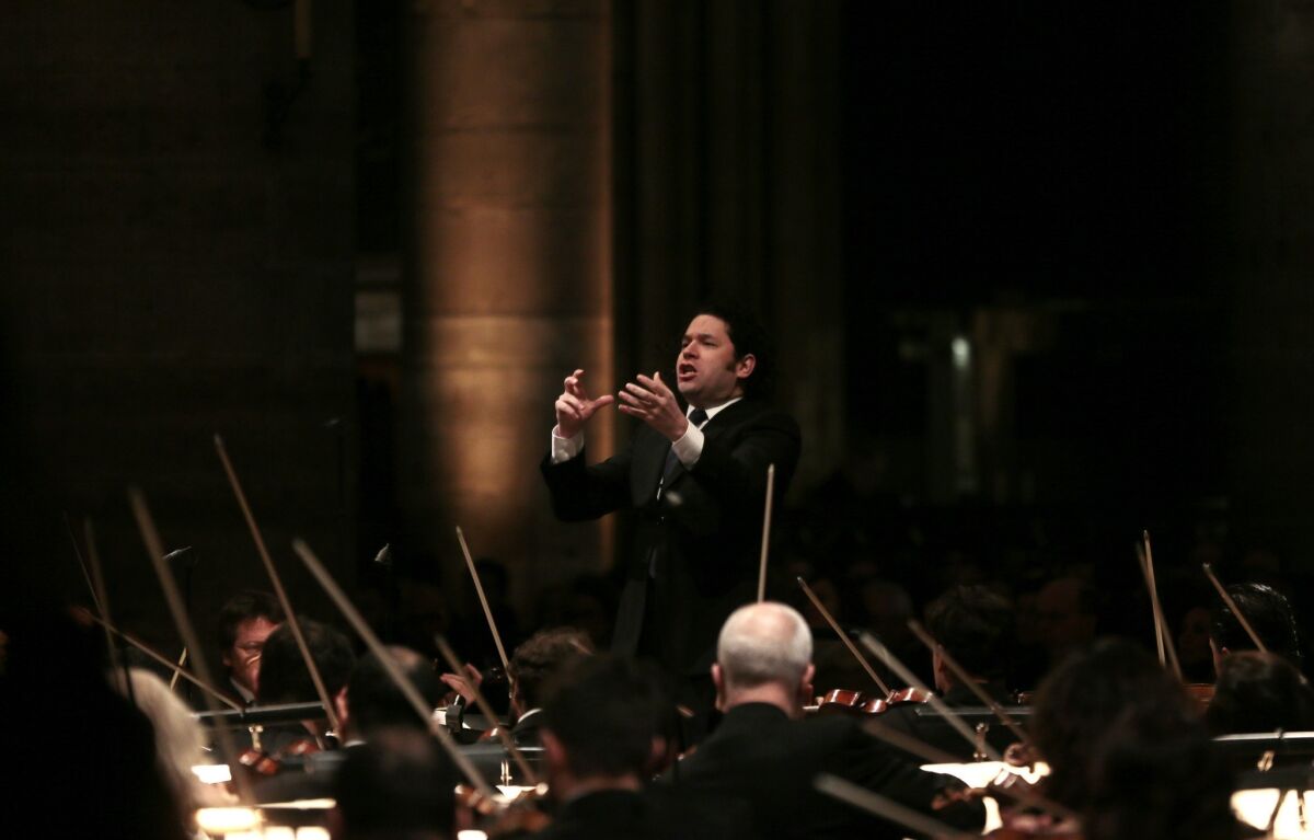 Venezuelan maestro Gustavo Dudamel, shown conducting the Orchestre Philharmonique de Radio France during rehearsals at the Notre-Dame de Paris cathedral late last month, issued a statement Thursday defending his appearance in Maracay, Venezuela, at a performance attended by Venezuelan President Nicolas Maduro. Three protesters were slain in clashes between pro- and anti-government groups on Wednesday.
