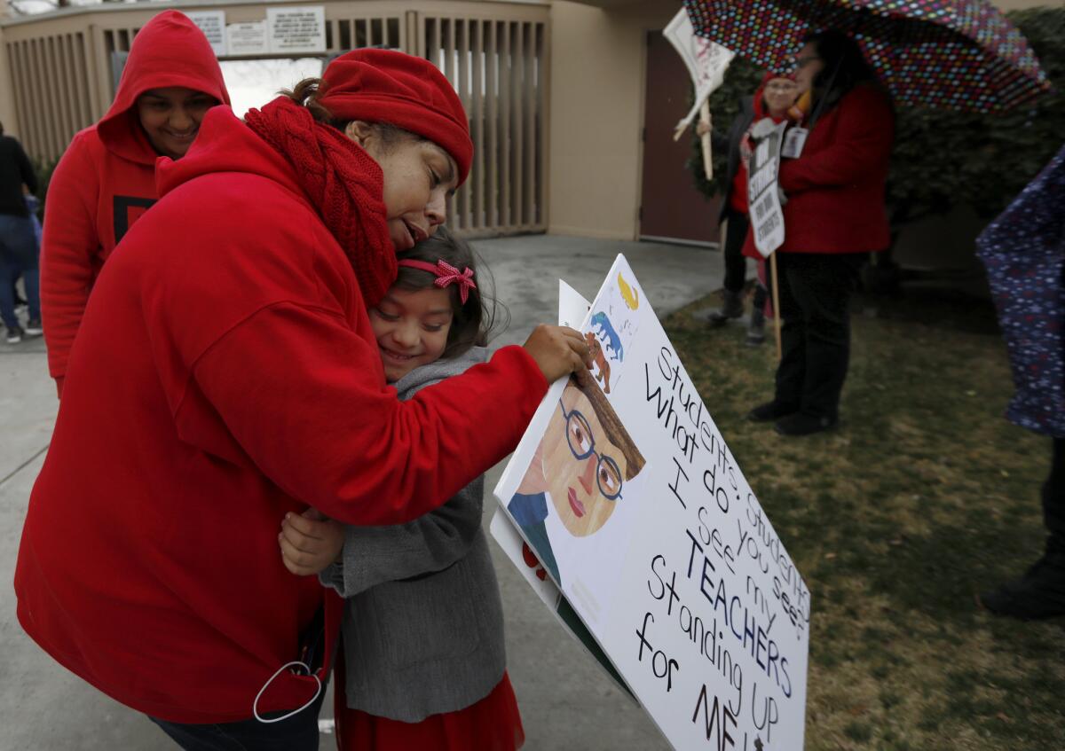 Kindergarten teacher Rita Ontiveros hugs student Alice Carrido, 5, on the picket line at Telfair Elementary School in Pacoima.