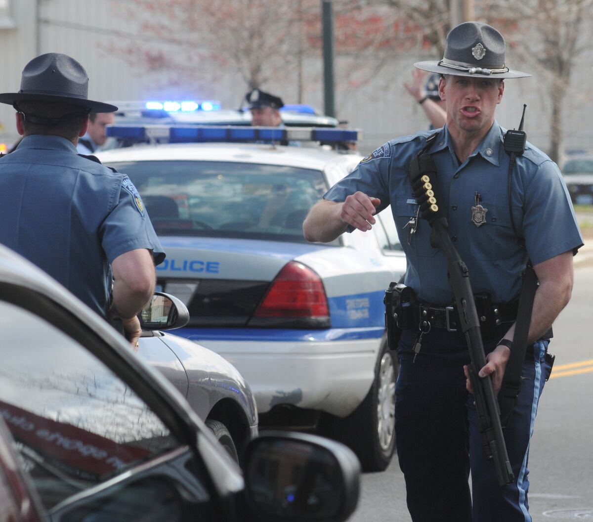 A Massachusett State Trooper pushes media back during a tense moment in the Watertown, Mass., manhunt for a suspect in the Boston Marathon bombings.