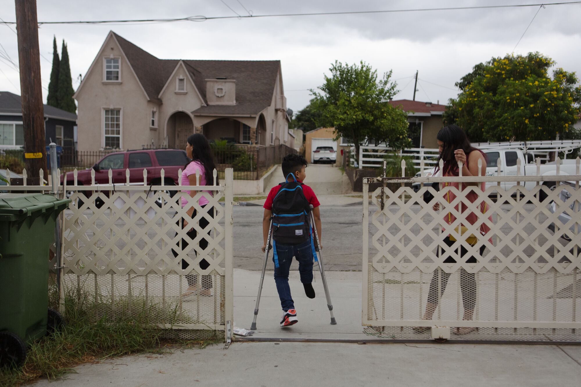 Efraín walks out of his house on crutches.