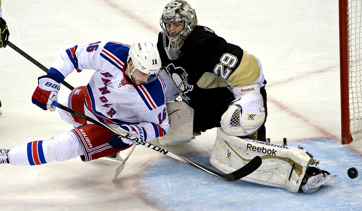 Rangers forward Derick Brassard gets the puck past Penguins goalie Marc-Andre Fleury as he falls to the ice for goal in the first period Friday night.
