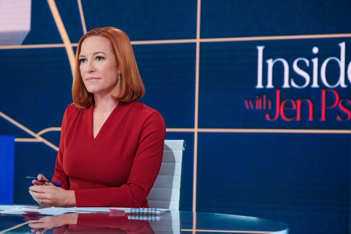 A woman in a red suit and red hair on the set of "Inside With Jen Psaki."
