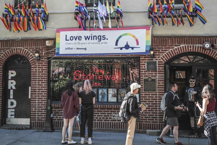 In this Monday, June 3, 2019, photo, pride flags and pride colors display on the Stonewall Inn bar, marking the site of 1969 riots that followed a police raid of the bar's gay patrons, in New York. Some of the coverage of the confrontation was a source fury that led Stonewall to become a synonym for the fight for gay rights. (AP Photo/Bebeto Matthews)