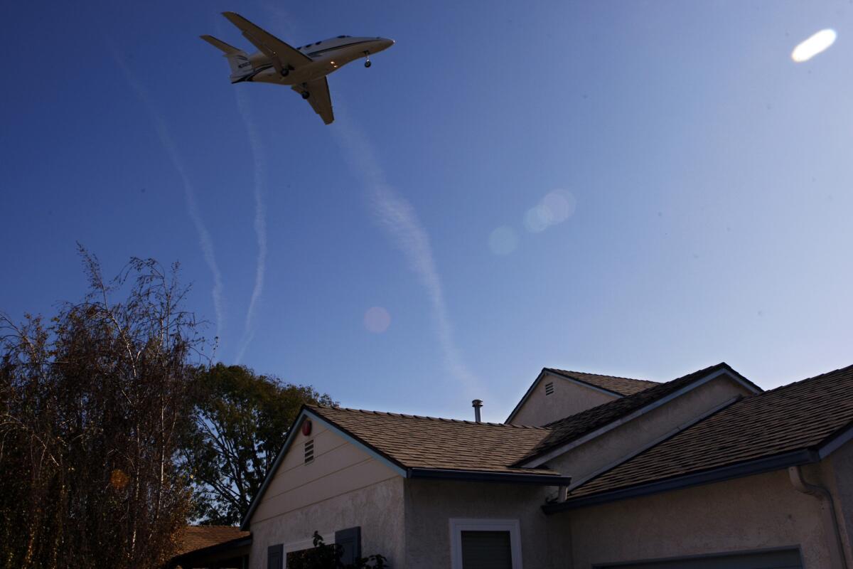 A plane flies over a Mar Vista home on approach to Santa Monica Airport. Noise and emissions from planes passing overhead has fueled an effort to close all or part of the airport.