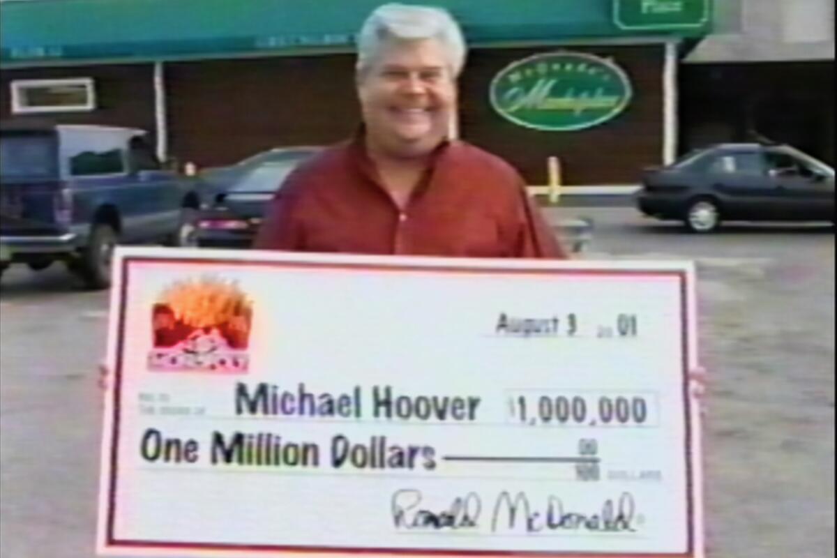 Michael Hoover holding an oversize check for one million dollars in "McMillions"