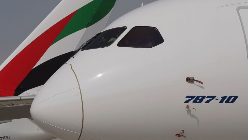 A Boeing 787-10 Dreamliner is parked in front of an Emirates Airline plane during the opening day of the Dubai Air Show on Nov. 12 in United Arab Emirates.