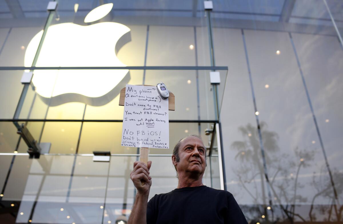 Joining a nationwide show of support, Tom Wolff holds a sign outside an Apple store in Santa Monica on Feb. 23 backing Apple's refusal to create software to circumvent security measures on a terrorist's phone.