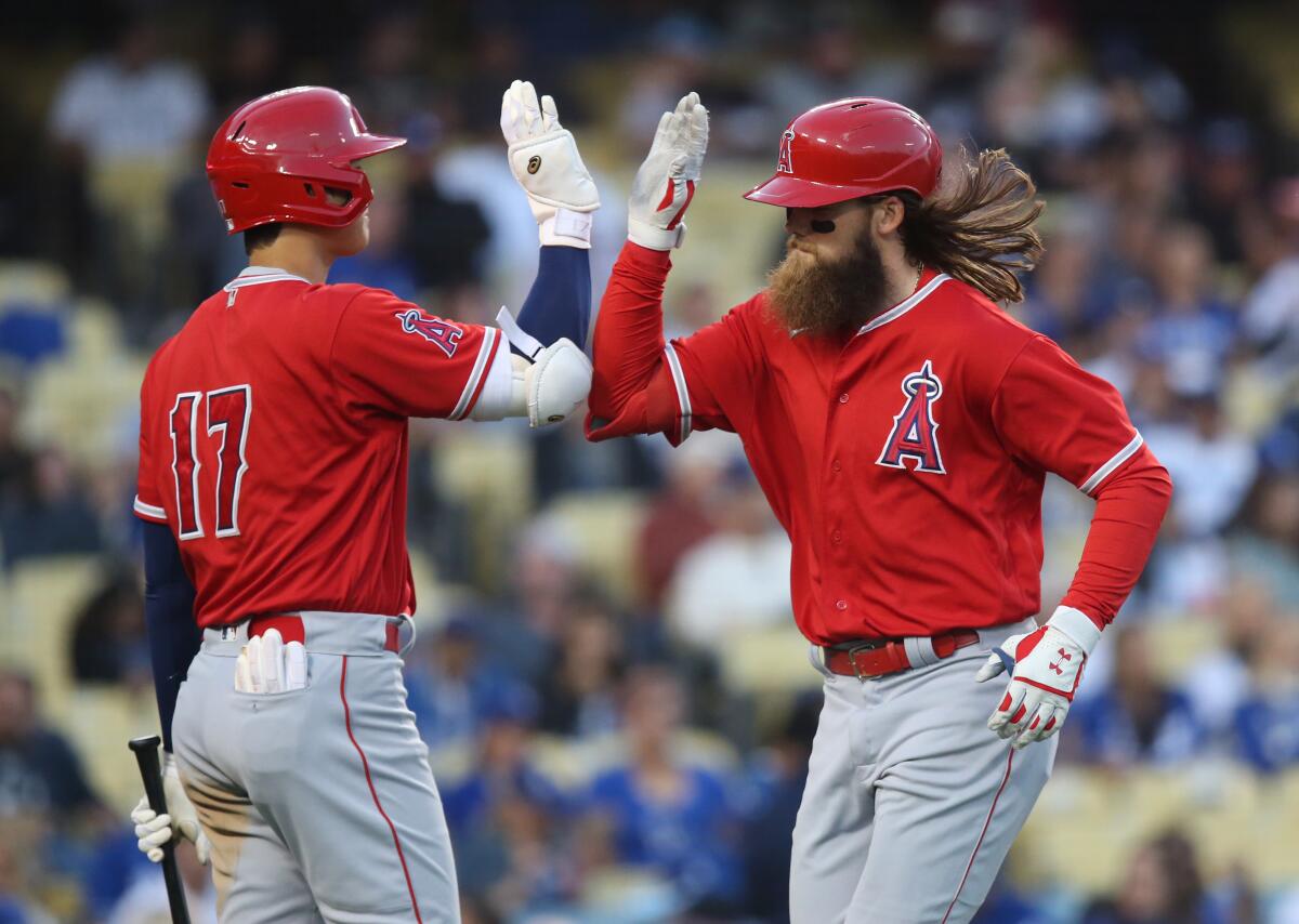 Los Angeles Angels Brandon Marsh, right, high-fives Shohei Ohtani after scoring.