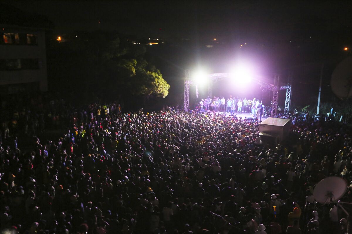 Thousands of people attend a music concert to celebrate New Year's in the Mbare suburb of Harare, Zimbabwe, early Friday, Jan 1, 2021. Despite a government ban on music concerts and public gatherings due to a surge in COVID-19 infections and the new and more contagious variants of the disease, thousands of people gathered in one of the country's poorest neighborhoods to celebrate the new year. (AP Photo/Tsvangirayi Mukwazhi)
