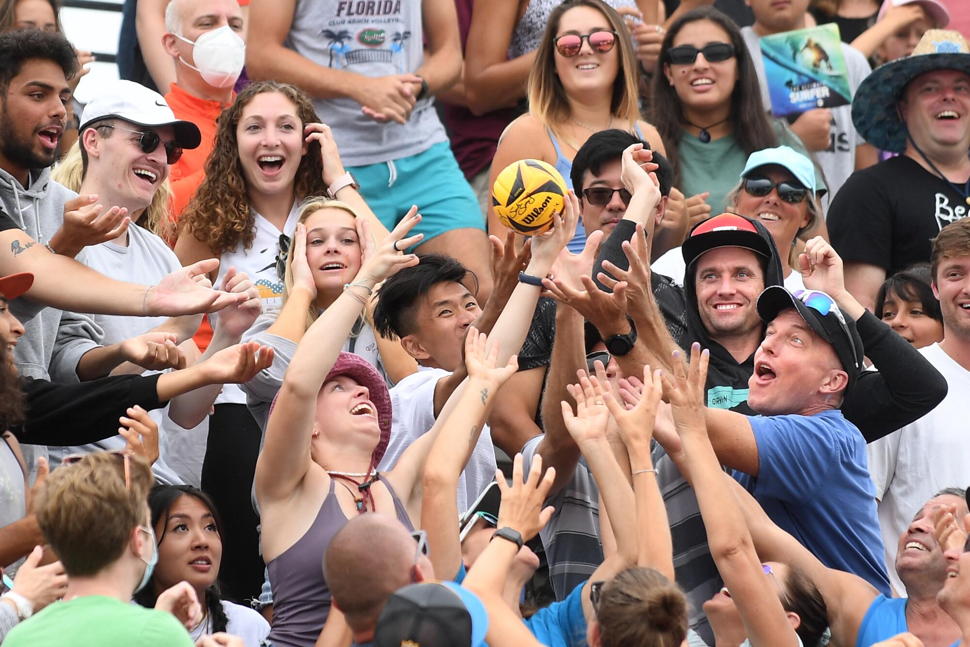 Fans scramble for a free volleyball tossed into the stands.