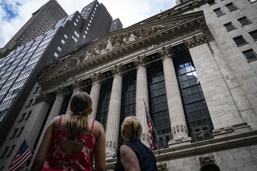 FILE - Pedestrians pass the New York Stock Exchange on July 14, 2022, in New York. The U.S. economy is caught in an awkward, painful place. A confusing one, too. Growth appears to be sputtering, home sales are tumbling and economists warn of a potential recession ahead. But consumers keep spending, businesses keep posting profits and the economy keeps adding hundreds of thousands of jobs a month. (AP Photo/John Minchillo, File)