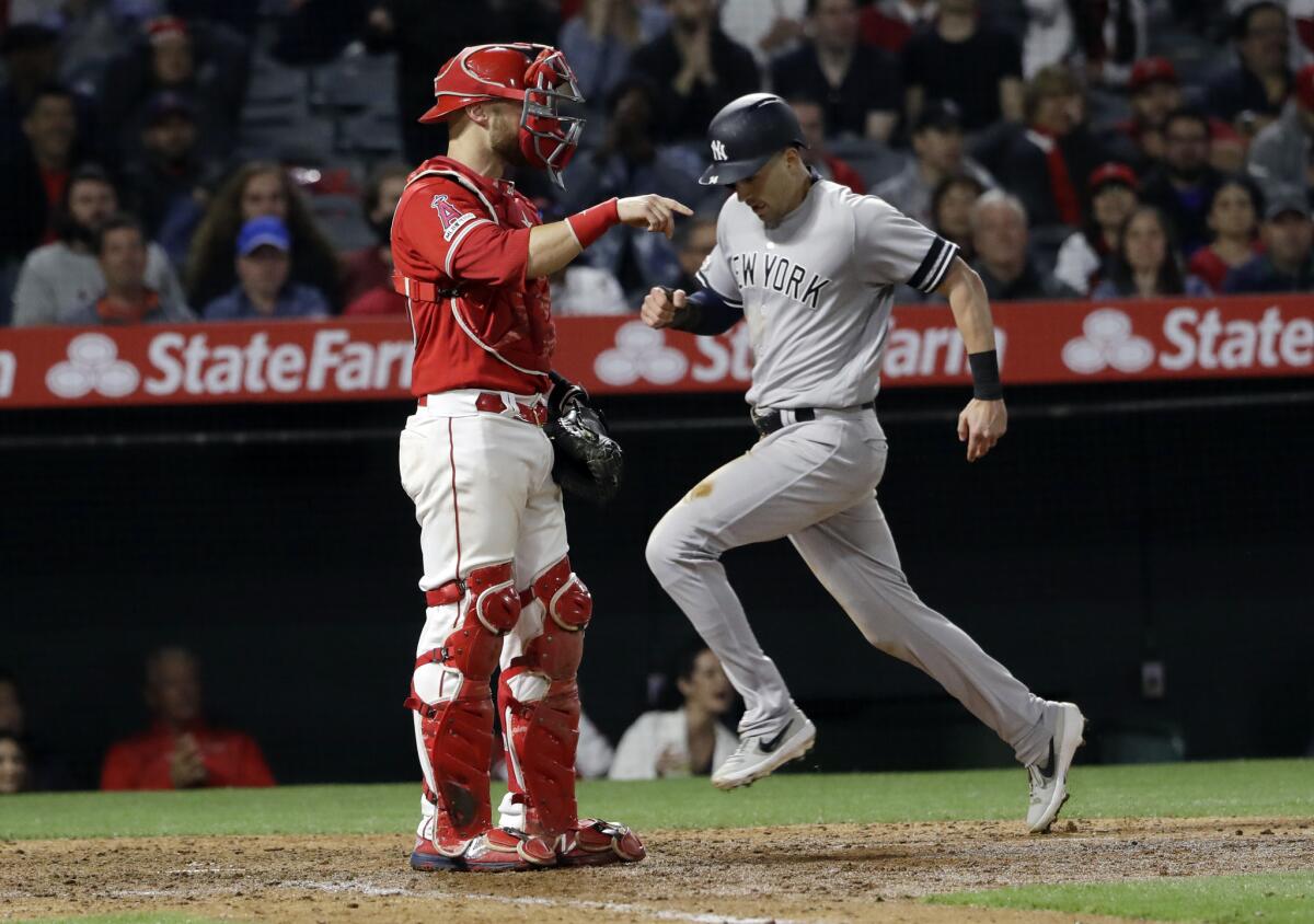 New York Yankees' Tyler Wade, right, scores on a single from DJ LeMahieu during the ninth inning against the Angels on Wednesday at Angel Stadium.