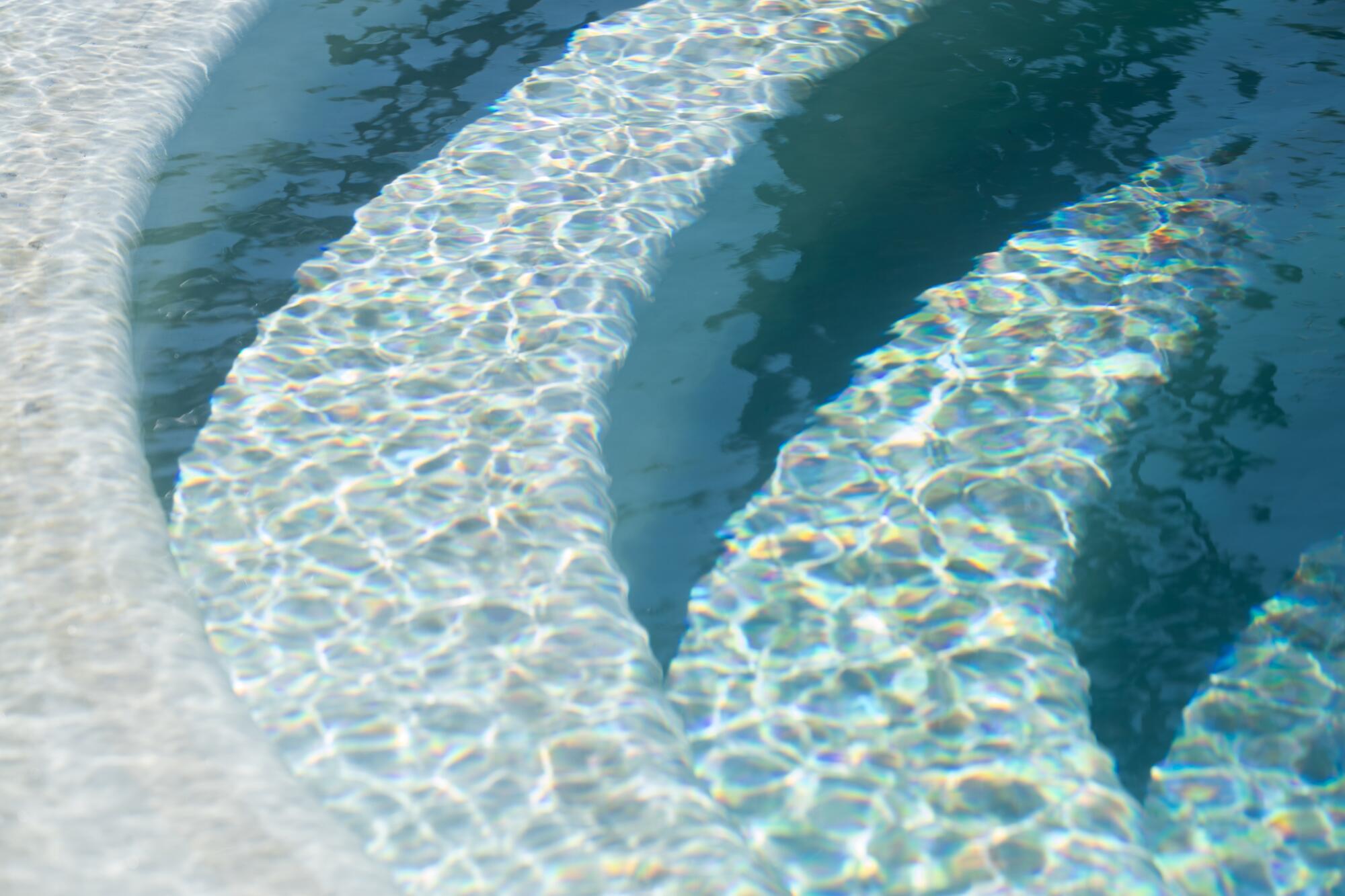 Sun-dappled water on the semicircular steps of a hot tub at Murrieta Hot Springs Resort. 