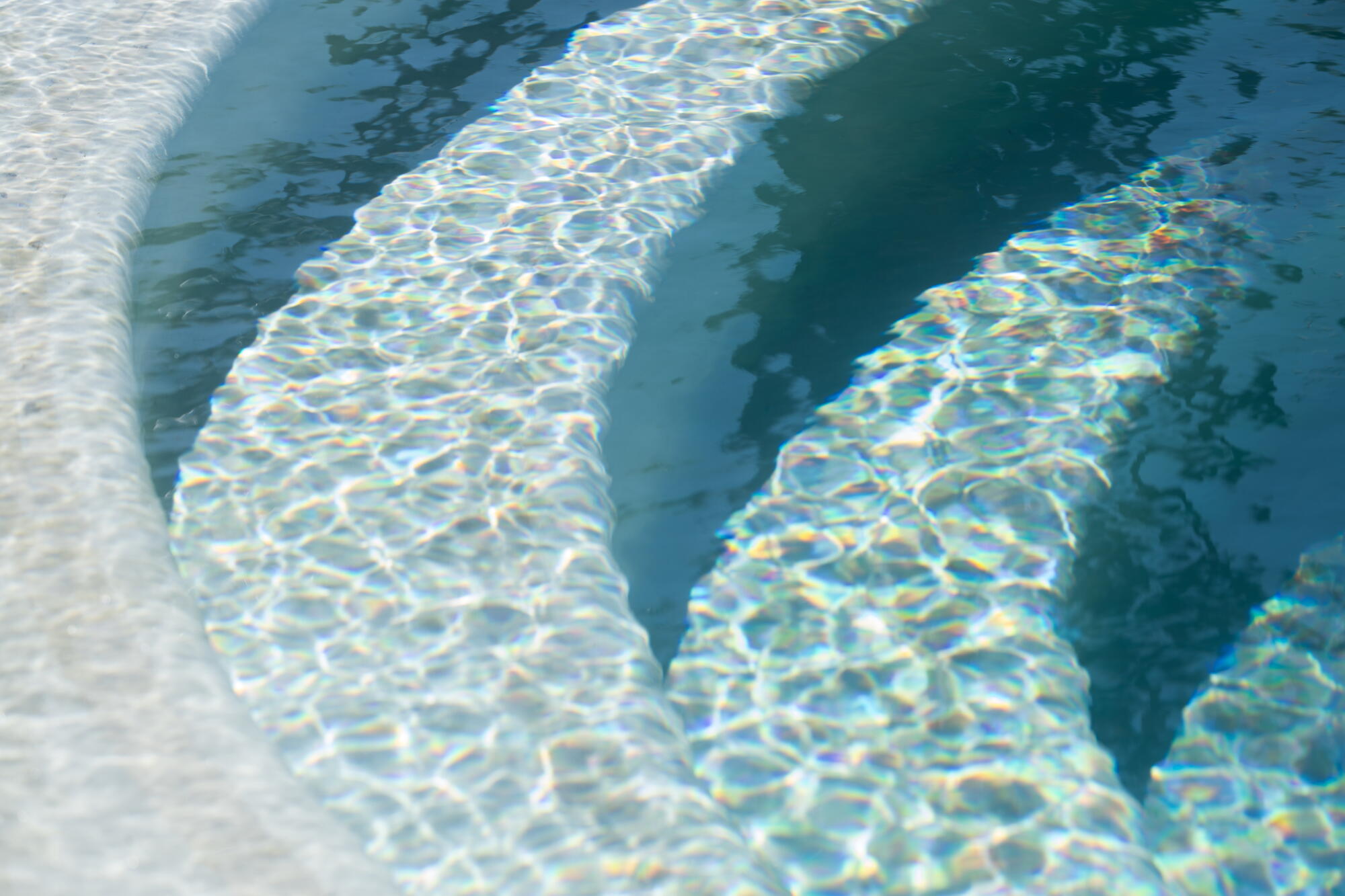 Sun-dappled water on the semicircular steps of a hot tub at Murrieta Hot Springs Resort.