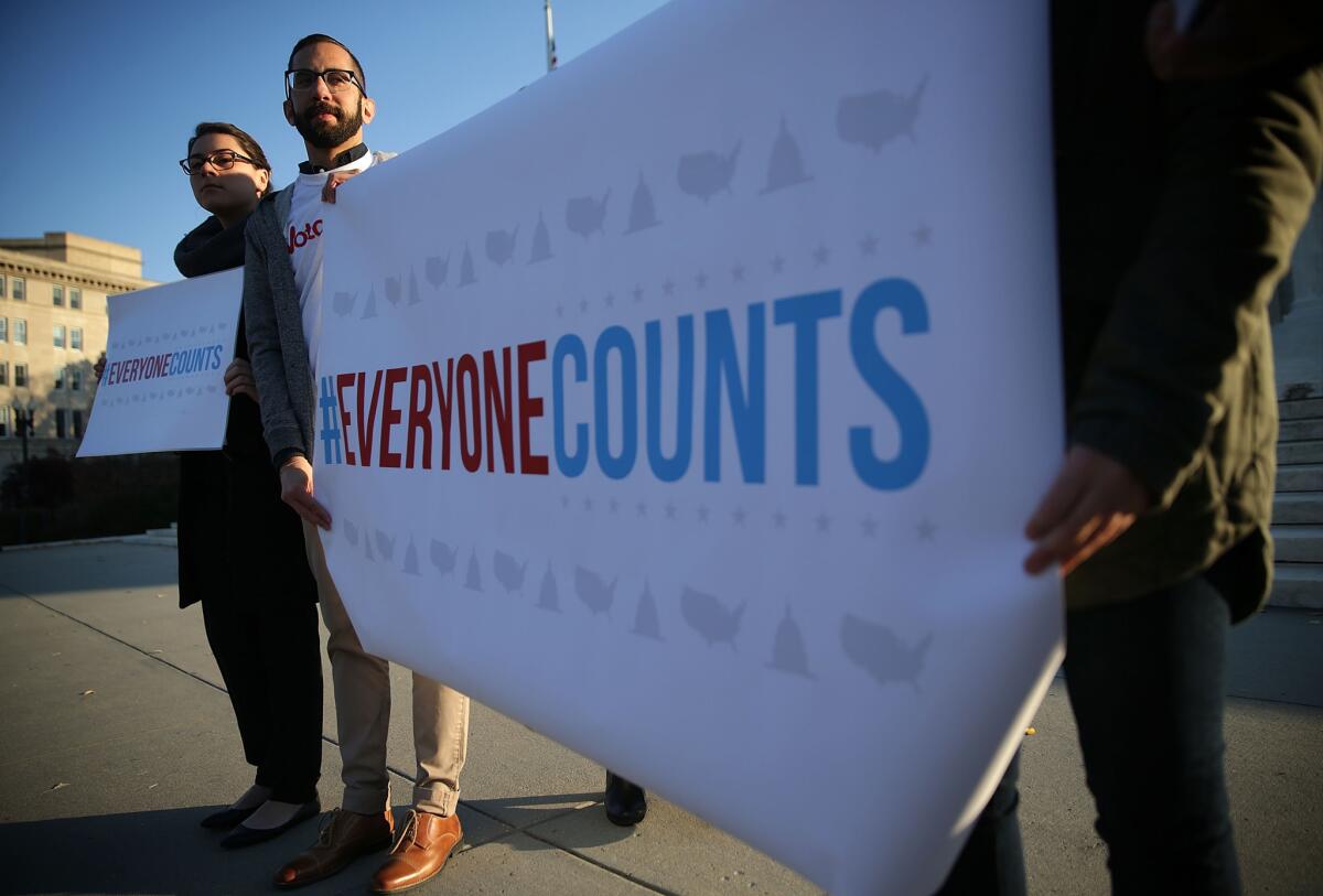 Activists hold signs during a news conference in front of the Supreme Court December 8, 2015 in Washington, DC.