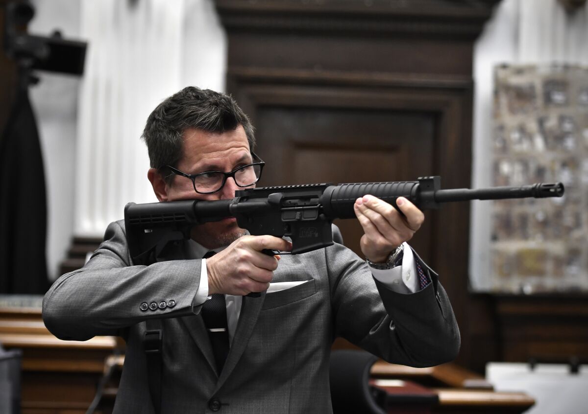 Assistant District Attorney Thomas Binger holds Kyle Rittenhouse's gun as he gives the state's closing argument in Kyle Rittenhouse's trial at the Kenosha County Courthouse in Kenosha, Wis., on Monday, Nov. 15, 2021. Rittenhouse is accused of killing two people and wounding a third during a protest over police brutality in Kenosha, last year. (Sean Krajacic/The Kenosha News via AP, Pool)