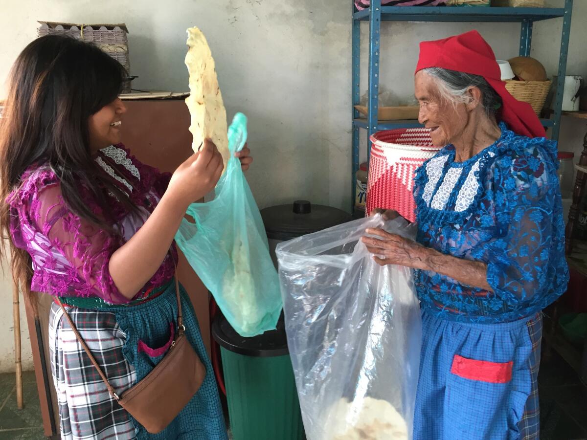 Veronica Martinez Sanchez helps her grandmother Sofia Gomez pack up freshly made Oaxacan-style tortillas. Martinez and Gomez spent most mornings in the kitchen, catching up over freshly brewed coffee and eggs.
