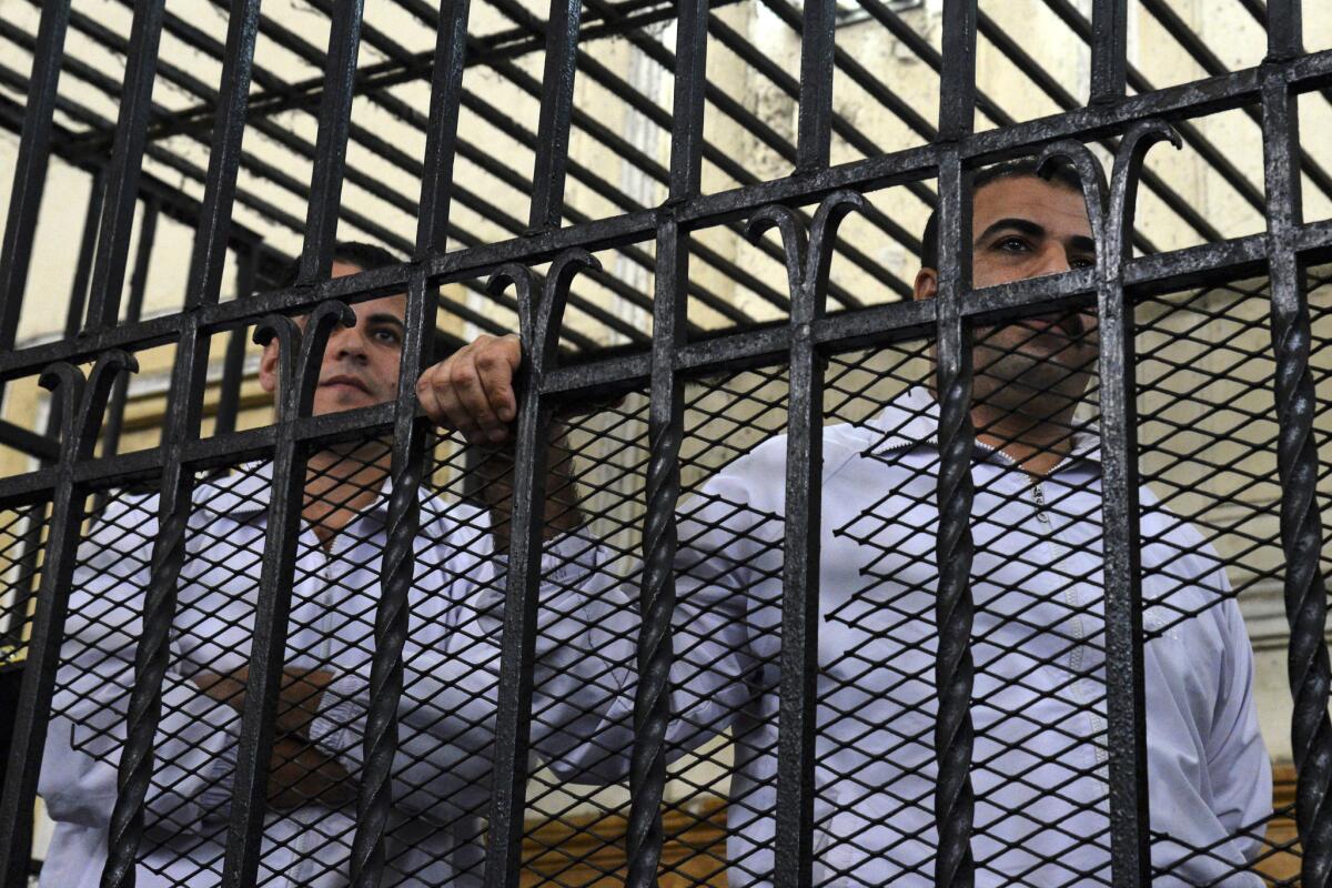 Egyptian police officers Awad Ismail Abdel Megued, right, and Mahmoud Salah Mahmoud Ghazala, stand in the dock Monday in an Alexandria courtroom where they were each sentenced to 10 years in prison in the beating death of 28-year-old Khaled Said.