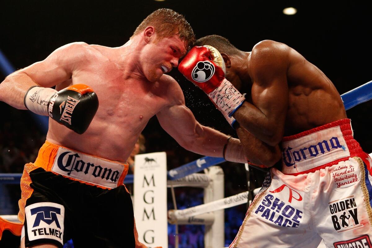 Saul "Canelo" Alvarez, left, digs a left to the body of Erislandy Lara during their junior-middleweight bout Saturday at the MGM Grand Garden Arena.