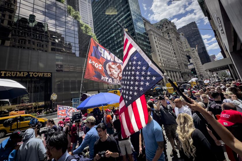 Un partidario del expresidente Donald Trump ondea una bandera estadounidense invertida durante una manifestación frente a la Torre Trump, el viernes 31 de mayo de 2024, en Nueva York. (AP Foto/John Minchillo)