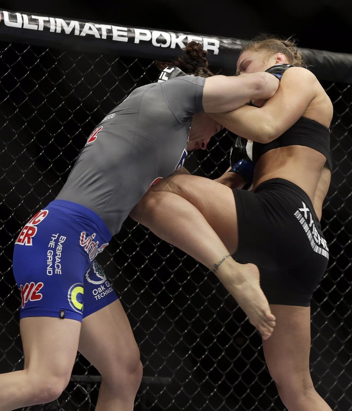 Ronda Rousey, right, knees Sara McMann during their UFC 170women's bantamweight title fight Saturday night in Las Vegas.