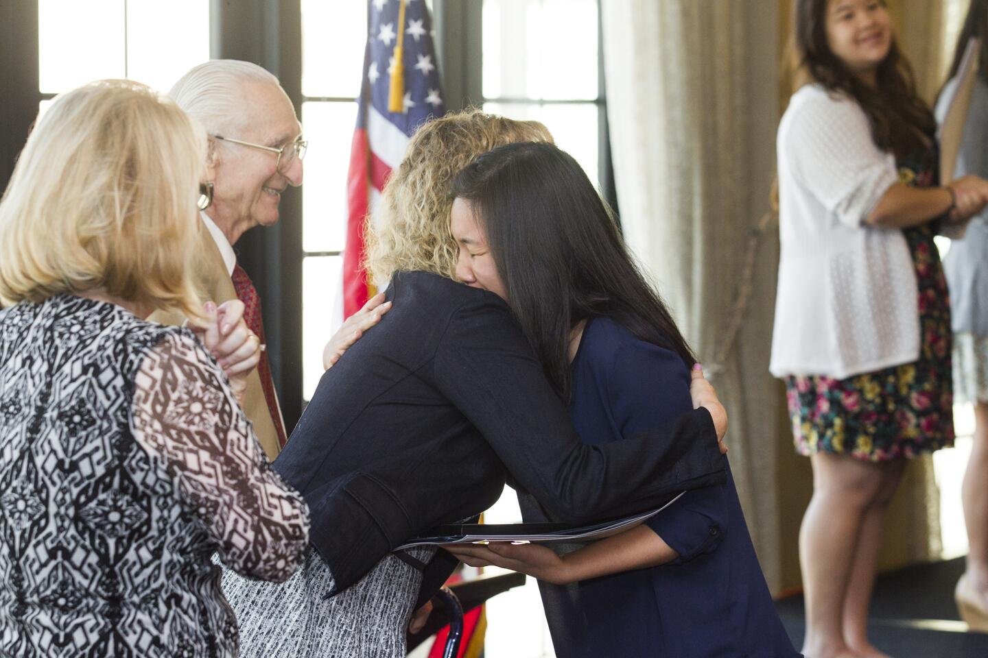 Costa Mesa High School's Audrey Nguyen receives a hug from Katrina Foley during the 35th annual Scholarship Recognition Breakfast, hosted by the Costa Mesa Chamber of Commerce on Friday, May 16. Nguyen received the Les Miller Outstanding Student Award. (Scott Smeltzer - Daily Pilot)