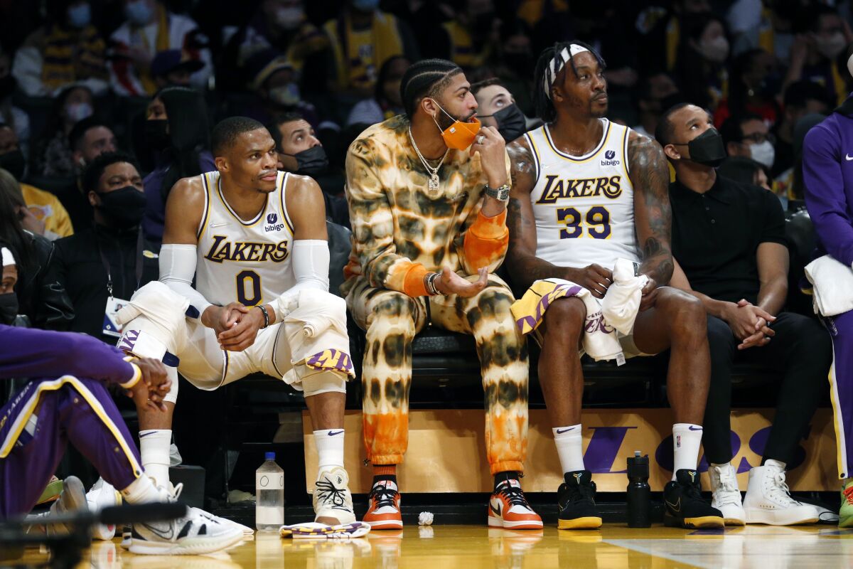 Lakers forward Anthony Davis sits on the bench between guard Russell Westbrook, left, and center Dwight Howard.