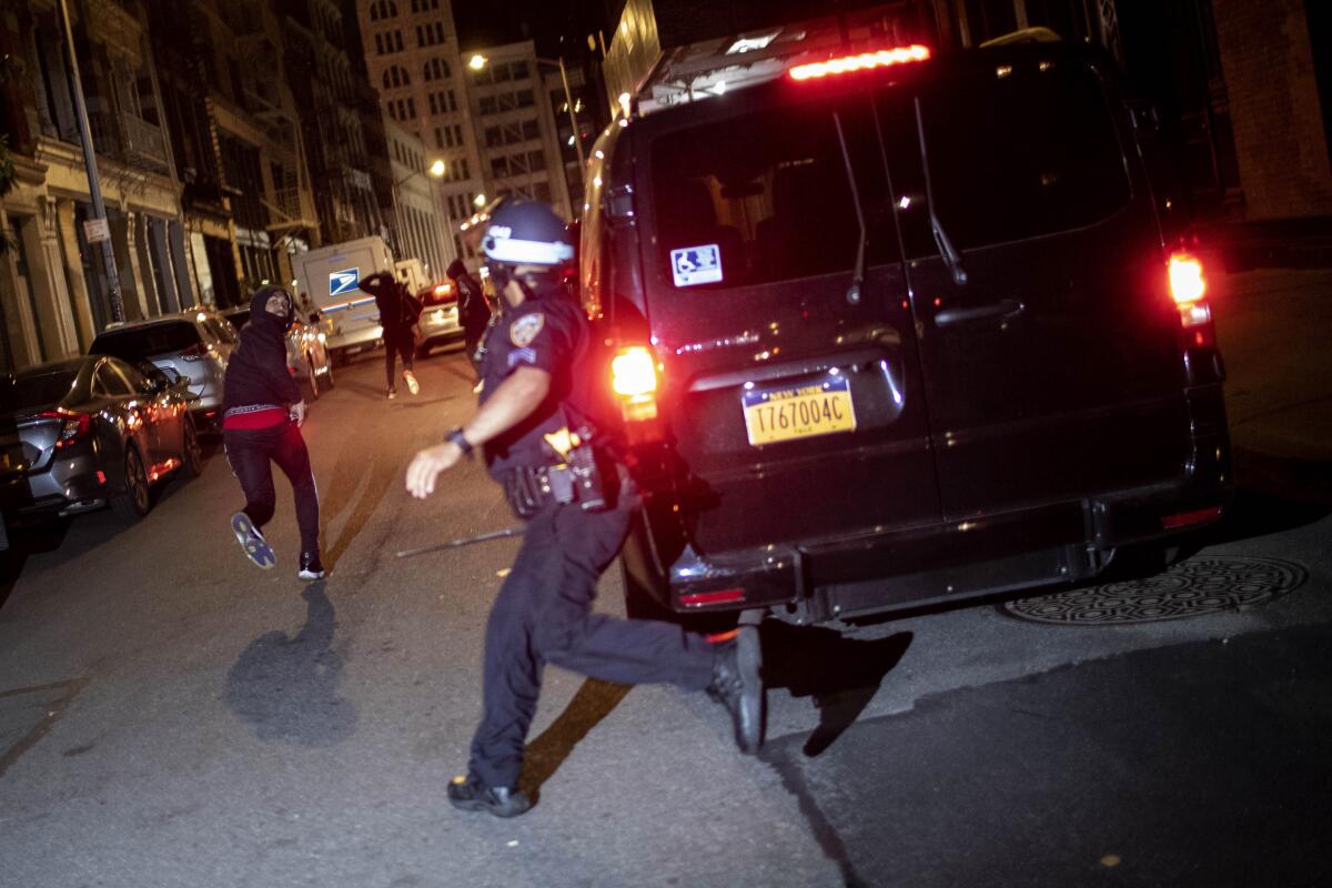 ARCHIVO - En esta foto de archivo del 1 de junio de 2020, un manifestante huye perseguido por la policía en Nueva York. 