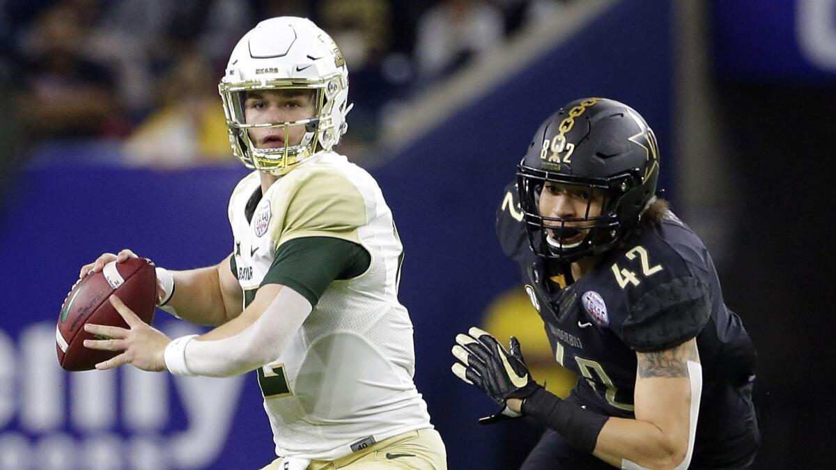 Baylor quarterback Charlie Brewer (12) looks to pass the ball as Vanderbilt linebacker Kenny Hebert (42) closes in during the first half.