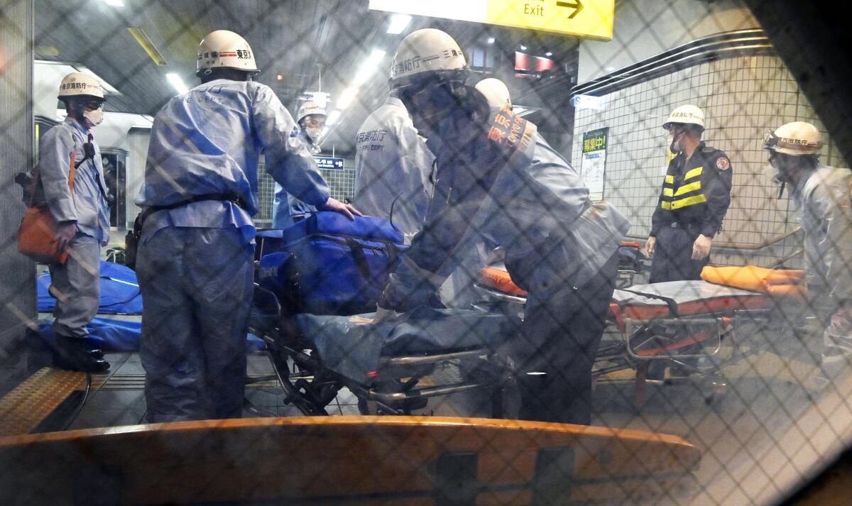 Rescuers prepare stretchers at Tokyo's Soshigaya-Okura Station after a Friday stabbing on a commuter train.