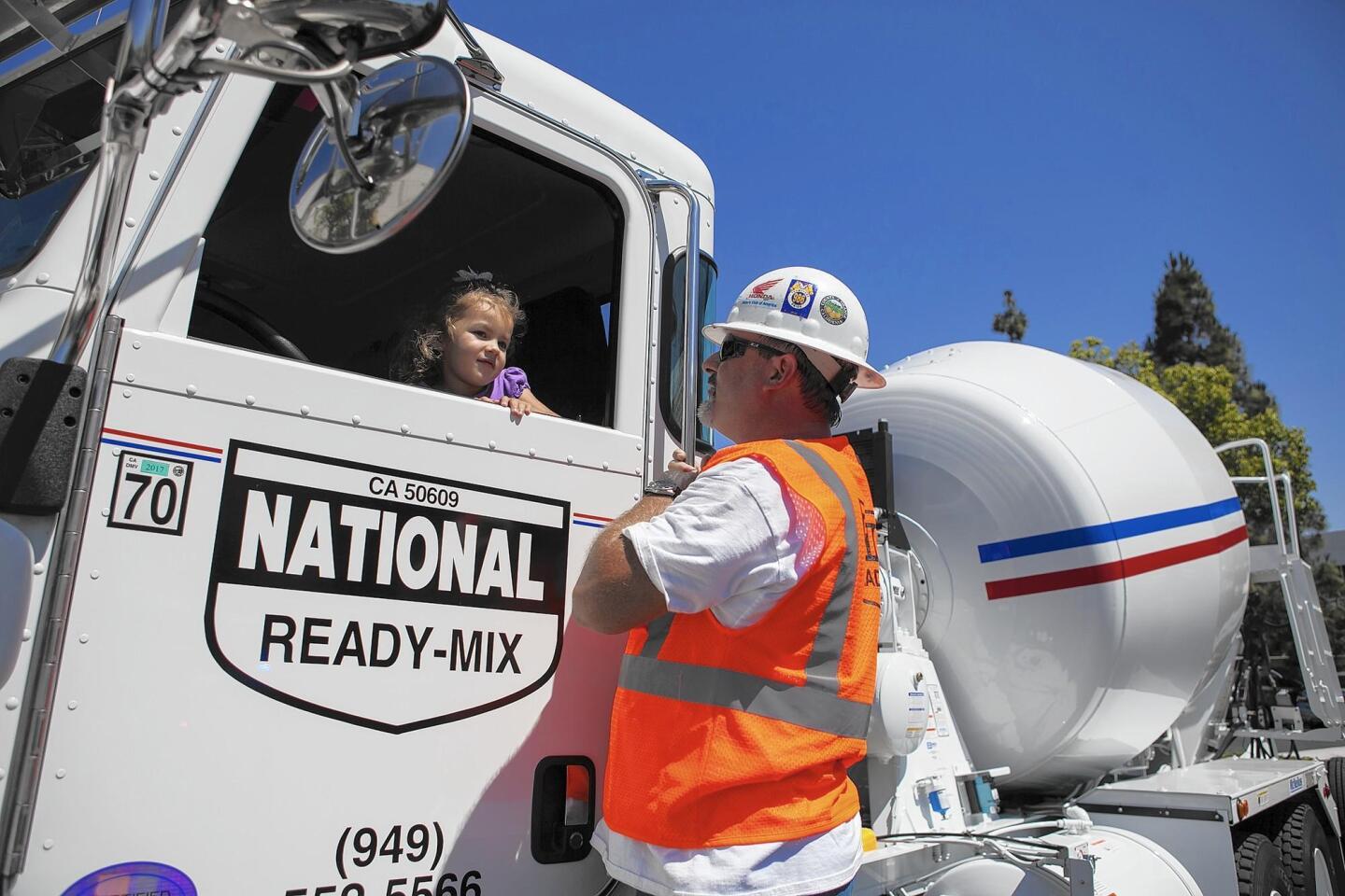 Sophia Andrade, 4, sits in a cement truck as she talks with Terry Kannedy of National Ready-Mix during Pretend City Children’s Museum’s seventh annual “When I Grow Up” day on Thursday.