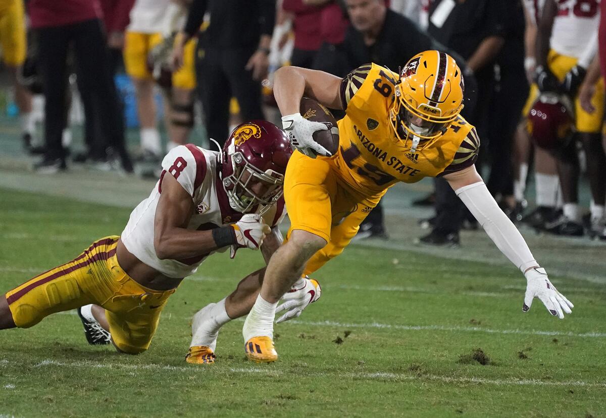 Arizona State receiver Ricky Pearsall fights for extra yardage against USC cornerback Chris Steele.