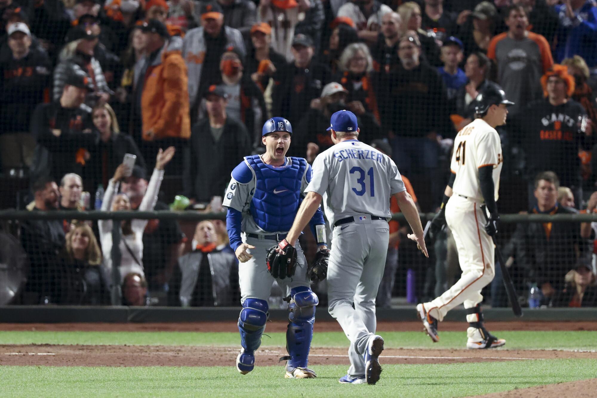 Dodgers catcher Will Smith, left, celebrates with Max Scherzer after Scherzer struck out Giants' Wilmer Flores 