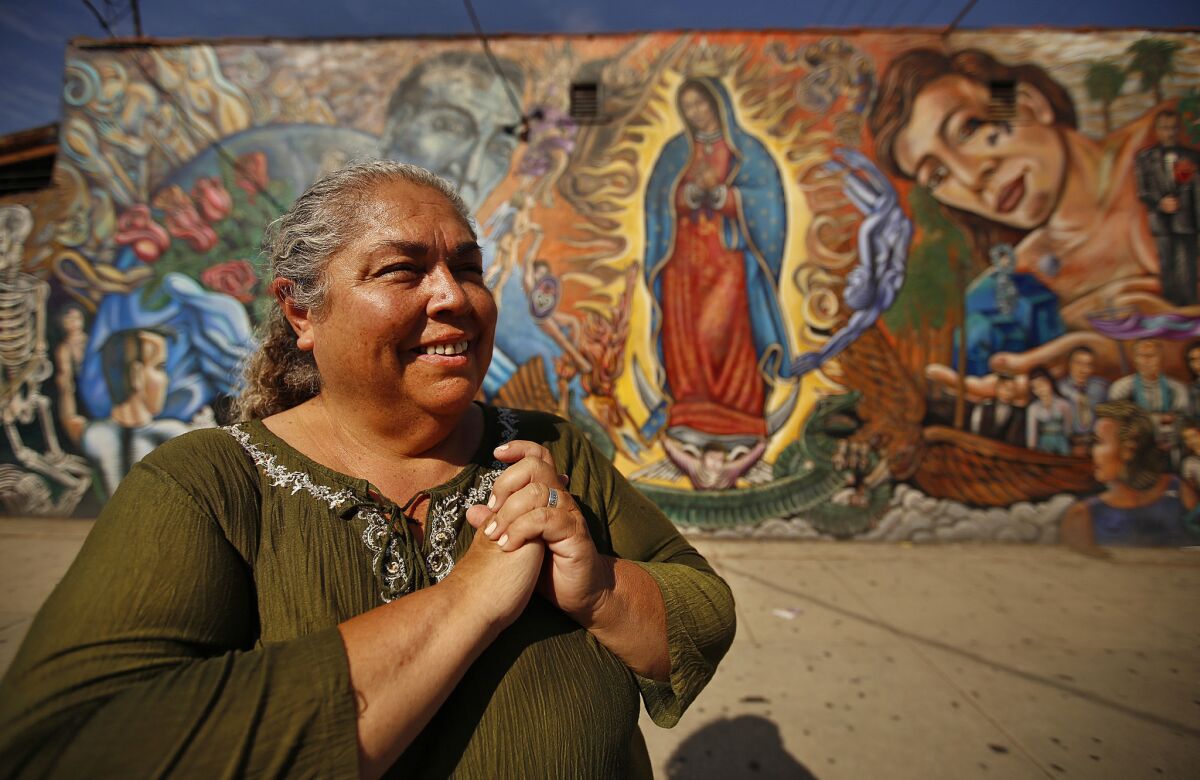 LOS ANGELES, CA SEPTEMBER 11, 2015 -- Rosa Manriquez in front of the Virgin's Seed mural by artist Paul Botello across the street from Our Lady of Guadalupe Church in East Los Angeles on September 11, 2015 where Manriquez has two daughters who are lesbians. Manriquez is going to Philadelphia later this month to the World Meeting of Families, part of Pope Francis' visit where she hopes to talk to the Pope, but she mostly wants to show the wider world of Catholics that her children were made in God's image too, that God loves them and that the church should embrace them. There is a lot of work to be done before that happens, but she is hopeful. (Al Seib / Los Angeles Times)