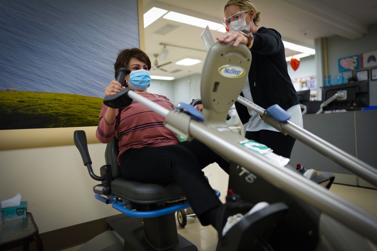 Carolina Nieto, 63 works on an exercise equipment with Suzanne Pruitt, Respiratory Therapist observing. 
