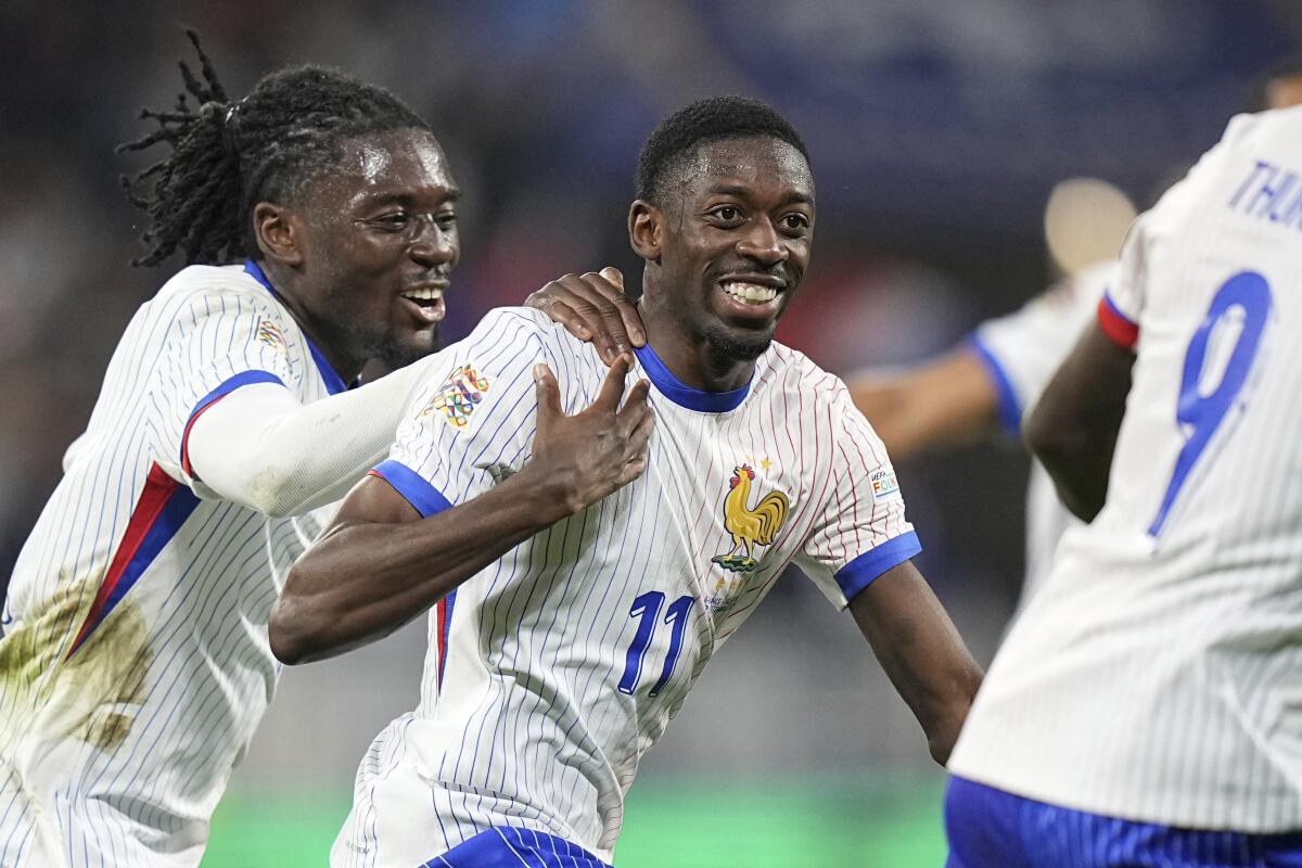 El francés Ousmane Dembélé (derecha) celebra junto a sus compañeros luego de anotar