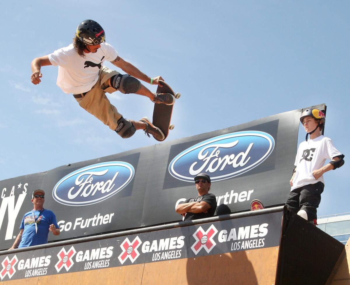 Bucky Lasek, left, competes in the X Games Skateboard Vert Final as fellow competitor Tom Schaar, 13, looks on Saturday at L.A. Live.