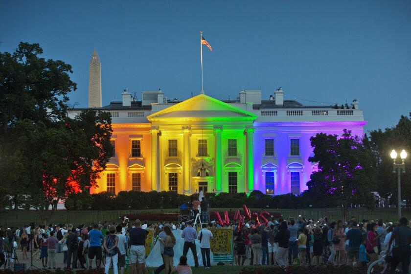 People gather in Lafayette Park to witness the White House being lit up in rainbow colors in commemoration of the Supreme Court's ruling to legalize same-sex marriage Friday, June 26, 2015, in Washington. Gay and lesbian couples in Washington and across the nation are celebrating Friday's ruling, which will put an end to same-sex marriage bans in the 14 states that still maintain them. (AP Photo/Pablo Martinez Monsivais)