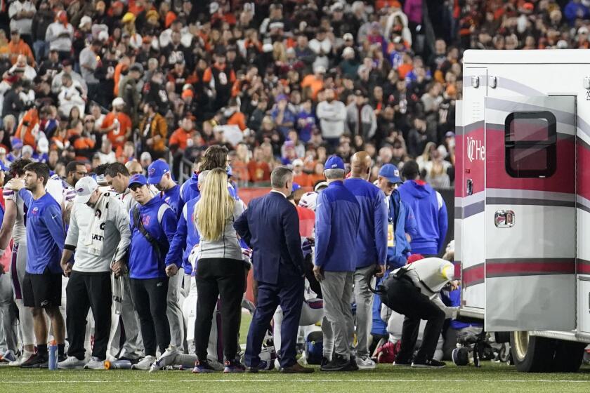Buffalo Bills players and staff pray for Buffalo Bills' Damar Hamlin during thegame against the Cincinnati Bengals