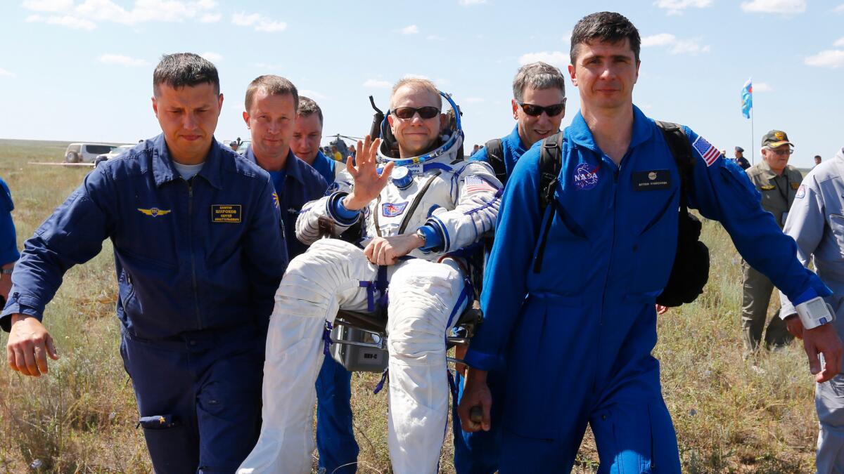 Ground personnel carry International Space Station crew member Tim Kopra of the U.S. shortly after landing near Zhezkazgan, Kazakhstan on June 18.