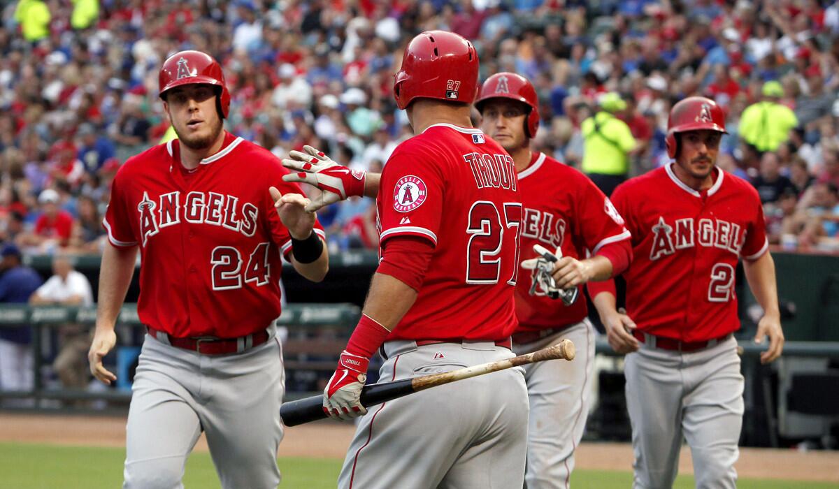 Los Angeles Angels designated hitter C.J. Cron (24) is greeted at home by Mike Trout (27) after he, David Freese, middle back, and Matt Joyce scored against the Texas Rangers during an Angels 8-2 rout.