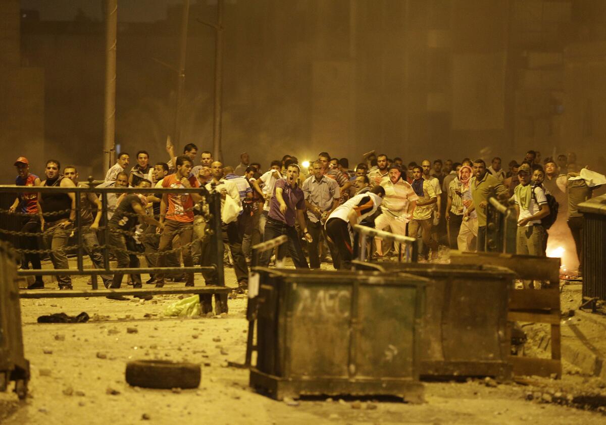 Supporters of Egypt's ousted president, Mohamed Morsi, throw stones at opponents and security forces during clashes in Cairo.