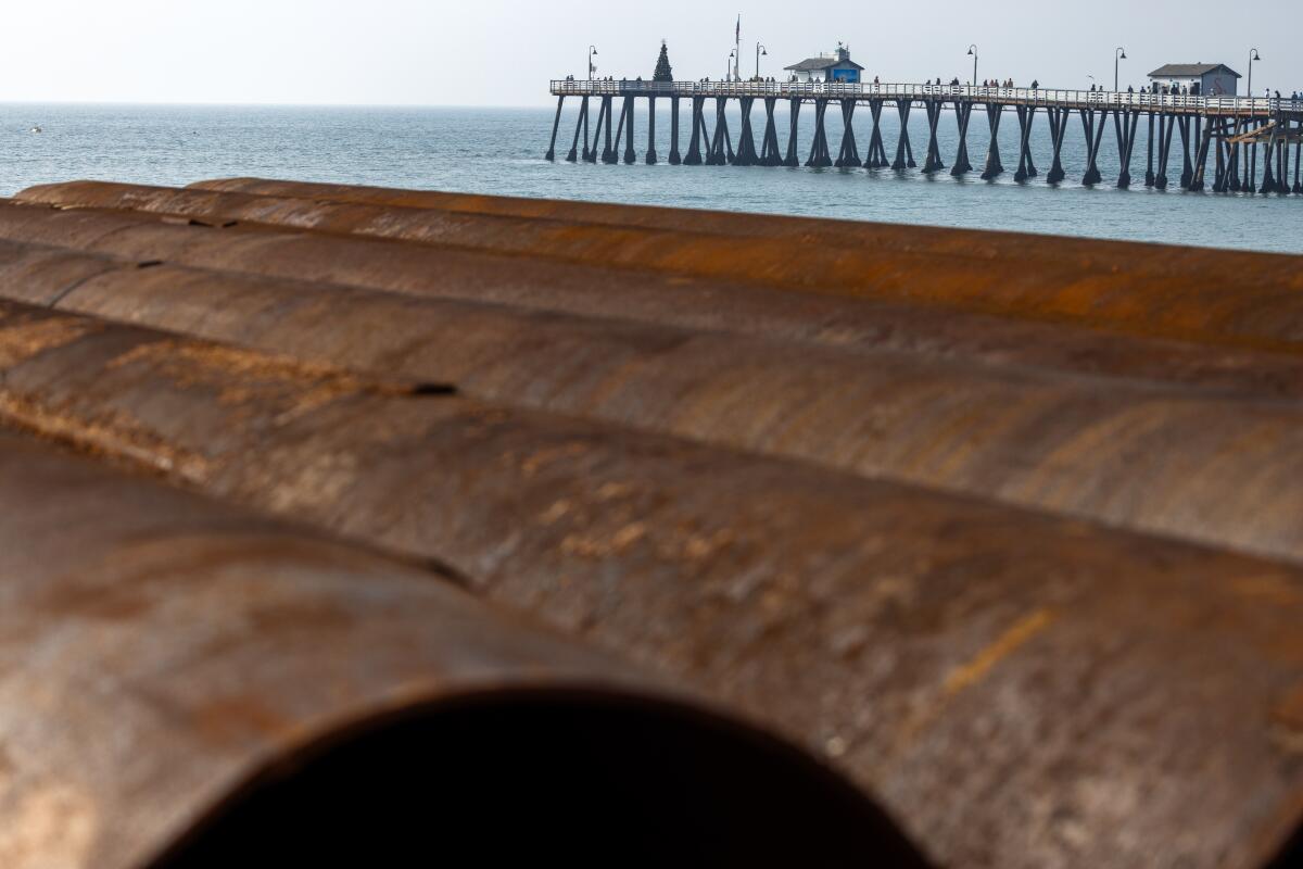 Large pipes rest near San Clemente's pier.