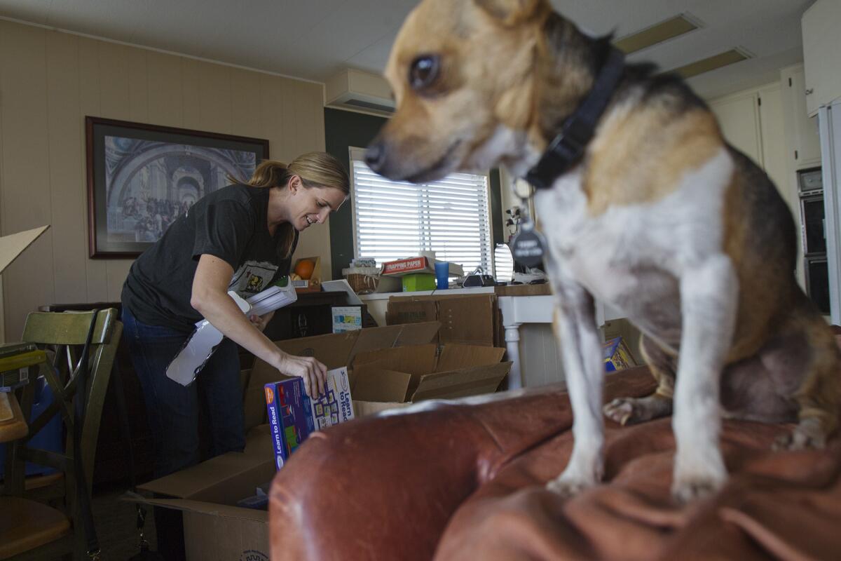 Erin Kunkle, left, a resident of Marina Park mobile home park, packs boxes with her family's belongings on Tuesday. The residents have been ordered to move out of the park by next week. (Scott Smeltzer, Daily Pilot)