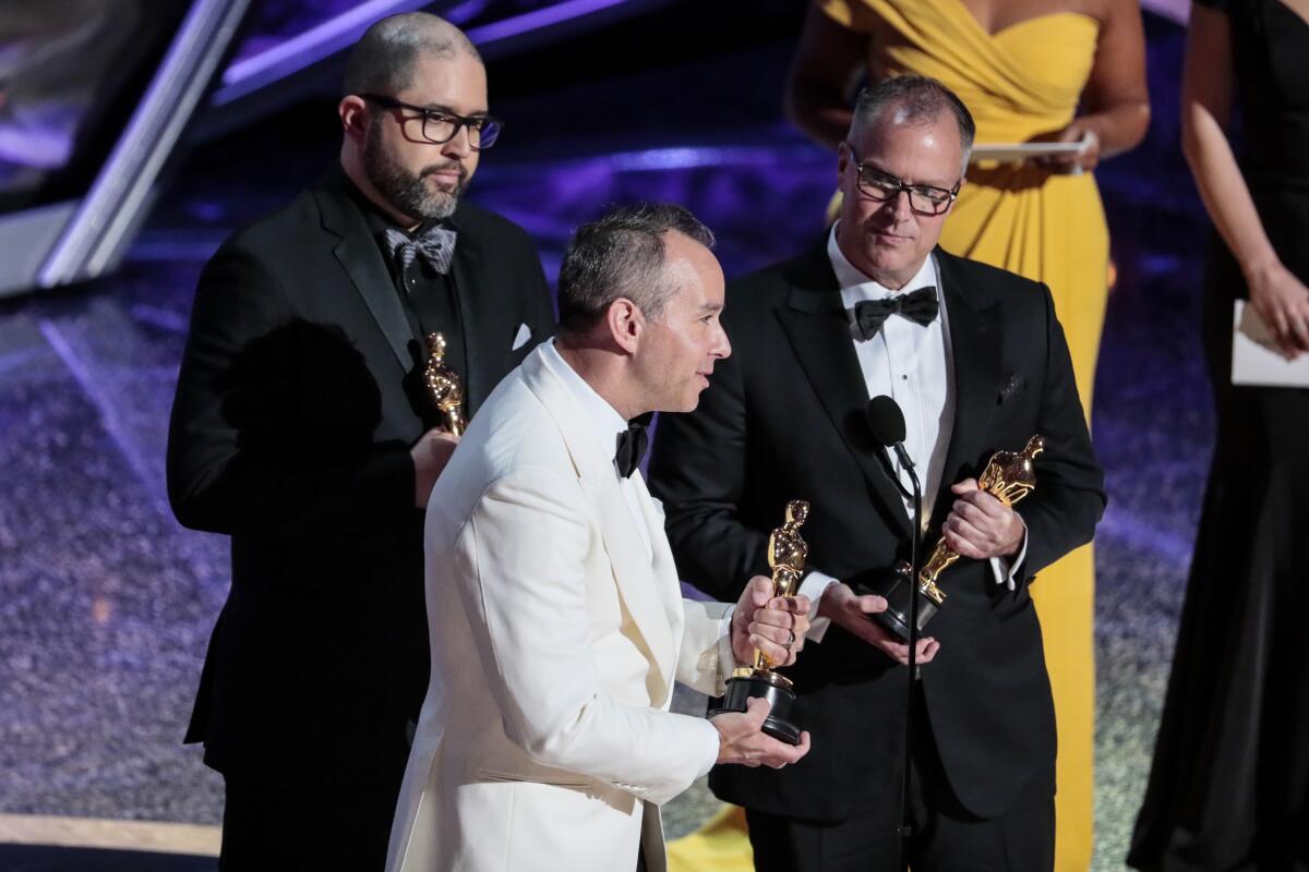 From left, Jonas Rivera, Josh Cooley and Mark Nielsen accept the Oscar for animated feature for “Toy Story 4."
