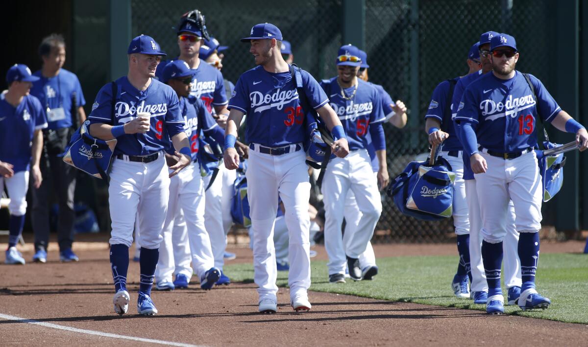 Dodgers Gavin Lux (9), Cody Bellinger (35) and Max Muncy (13) walk onto the field before a Cactus League game against the Chicago White Sox at Camelback Ranch on Feb. 24.