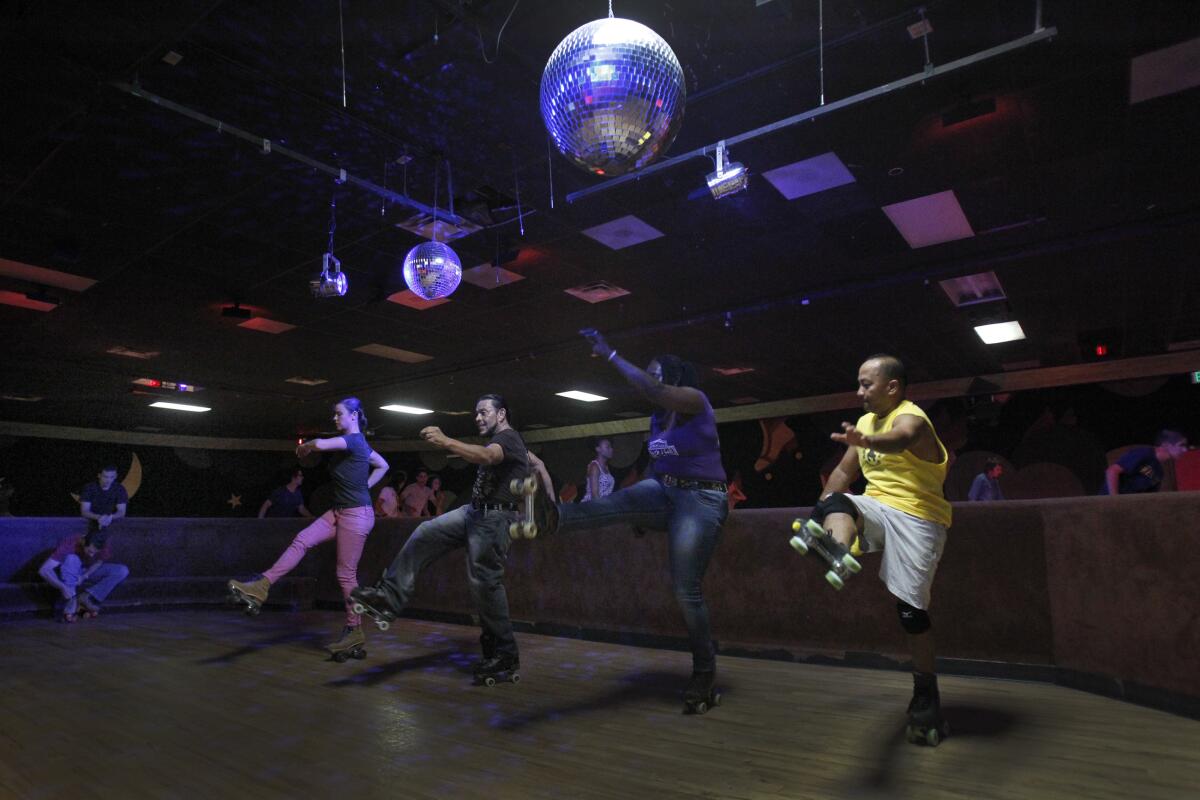 Skaters participate in a dance routine under disco balls at the World on Wheels roller skating rink in 2013.