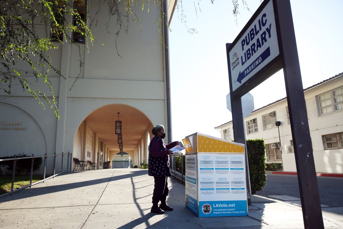 A woman drops off her ballot in an official ballot box in Huntington Park.